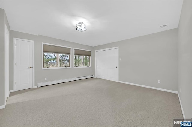 carpeted spare room with baseboards, visible vents, and baseboard heating