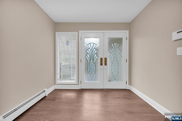 doorway featuring a baseboard heating unit, french doors, baseboards, and wood finished floors