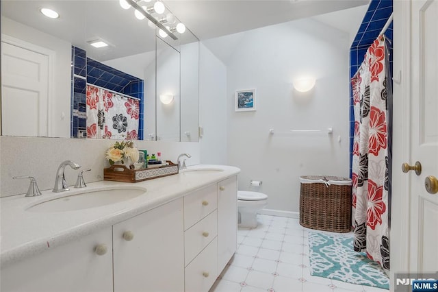 full bathroom featuring double vanity, a sink, toilet, and tile patterned floors