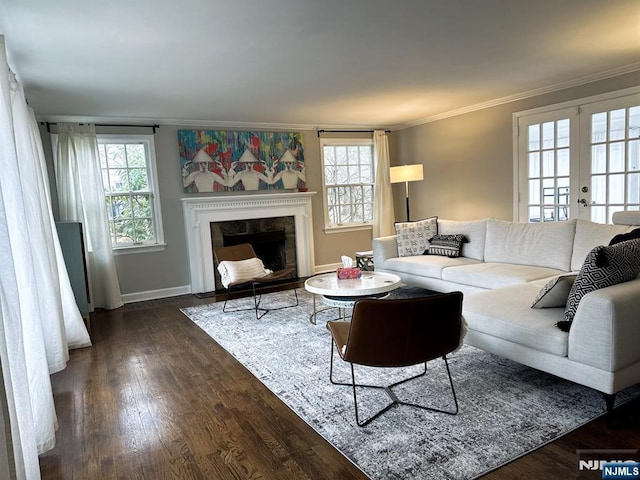 living room with dark wood-type flooring, a high end fireplace, baseboards, french doors, and ornamental molding