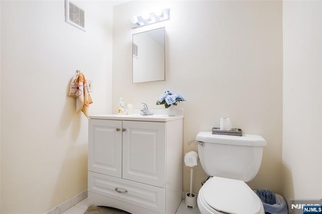 half bath with toilet, vanity, visible vents, and baseboards