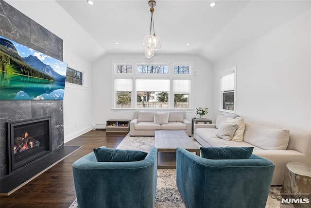 living area featuring a baseboard radiator, recessed lighting, a premium fireplace, wood finished floors, and vaulted ceiling