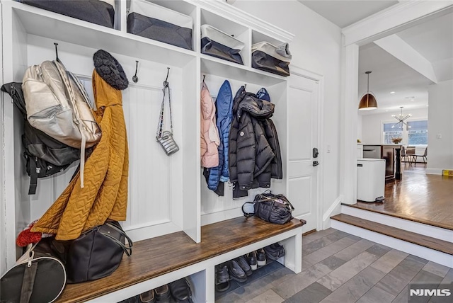 mudroom with wood finished floors and an inviting chandelier