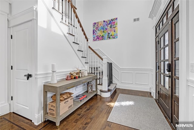 entrance foyer with dark wood-style floors, french doors, visible vents, a decorative wall, and stairway