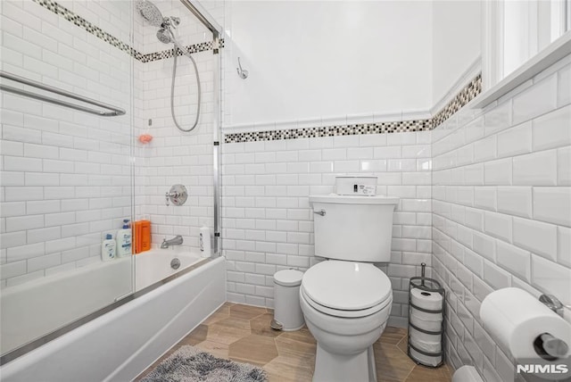 full bath featuring a wainscoted wall, shower / bath combination, tile walls, and toilet