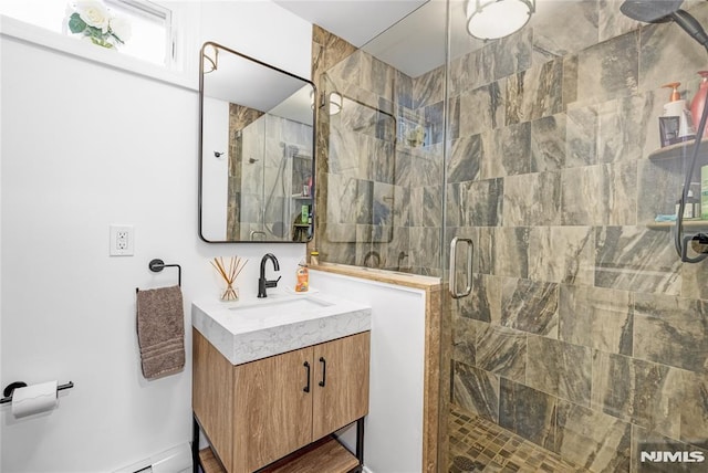 bathroom with a stall shower, baseboard heating, and vanity