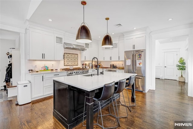 kitchen featuring stove, a sink, visible vents, high end fridge, and dark wood-style floors