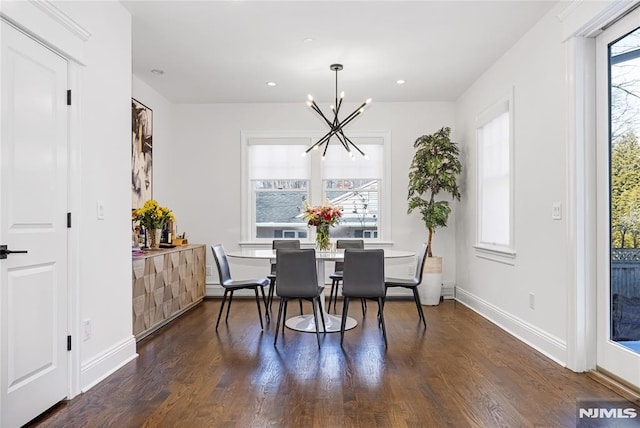 dining room with dark wood-style floors, a notable chandelier, and a healthy amount of sunlight