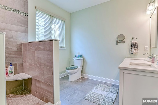 full bath featuring vanity, walk in shower, toilet, and baseboards