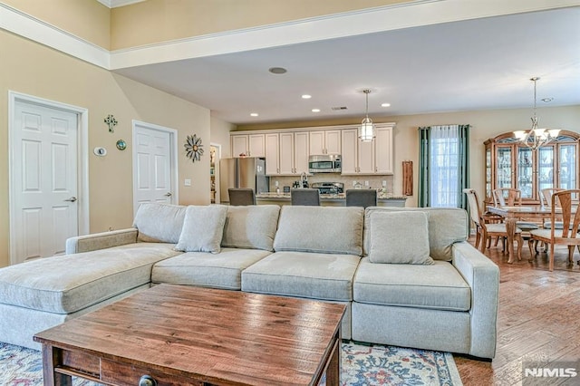 living room featuring a chandelier, recessed lighting, and light wood finished floors