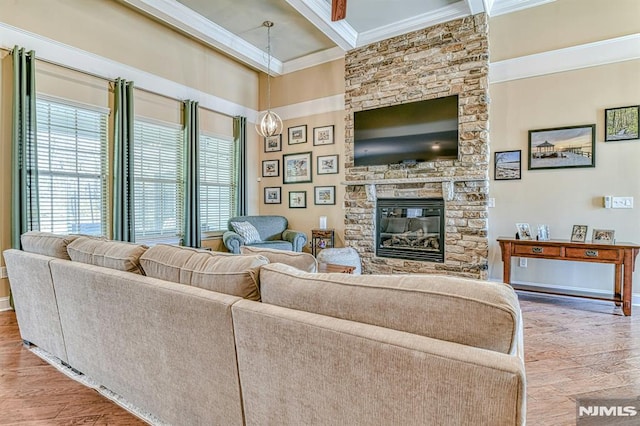 living area with beam ceiling, ornamental molding, a fireplace, and wood finished floors