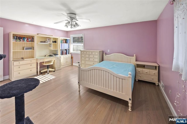 bedroom featuring a ceiling fan, baseboards, and wood finished floors