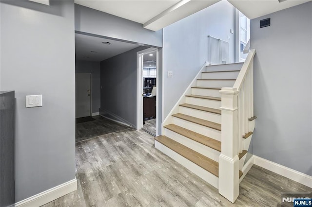 staircase with baseboards and wood finished floors