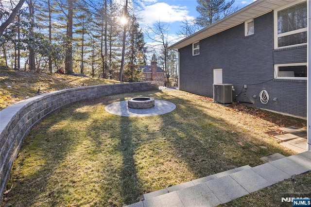 view of yard with an outdoor fire pit and central AC