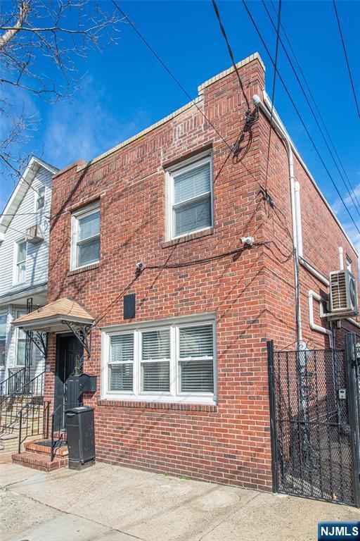 view of front of home featuring brick siding and ac unit