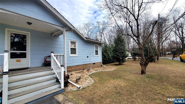 view of side of home featuring a yard and crawl space