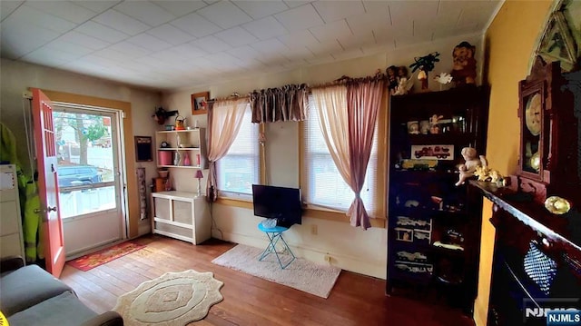 living area with baseboards and wood finished floors