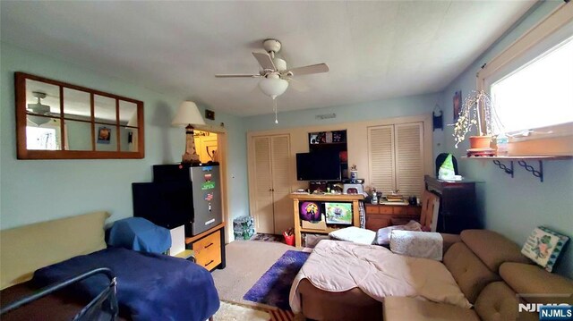 carpeted living area with ceiling fan