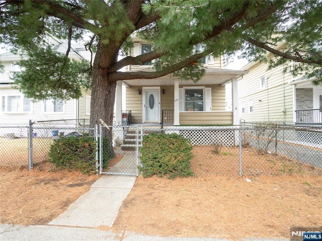 view of front facade with a porch, a fenced front yard, and a gate