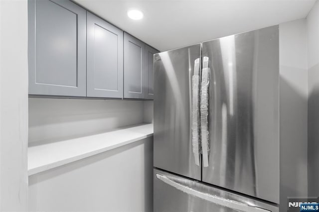 room details featuring recessed lighting, gray cabinets, light countertops, and freestanding refrigerator