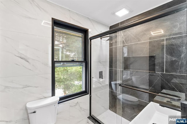 full bathroom with marble finish floor, a shower stall, and toilet