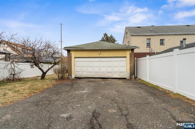 garage with driveway and fence