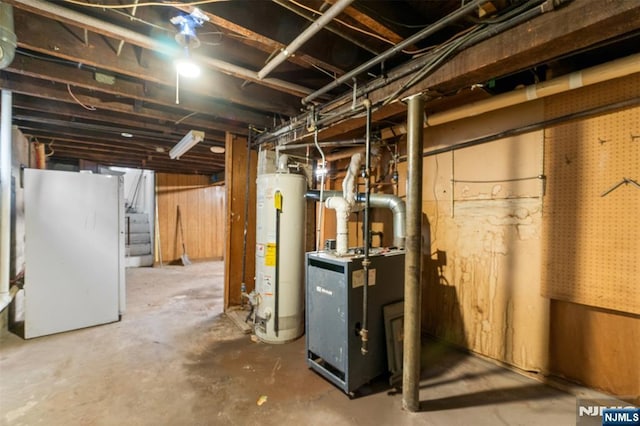 unfinished basement with freestanding refrigerator and water heater