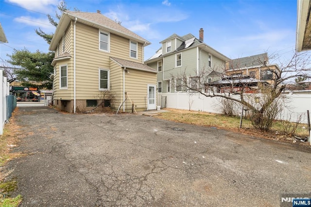 rear view of house featuring fence