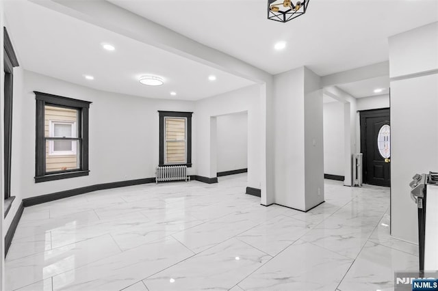 spare room with recessed lighting, radiator, marble finish floor, and baseboards