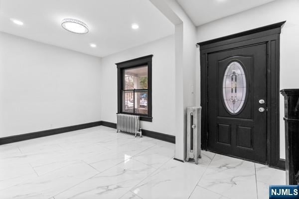 entryway with recessed lighting, marble finish floor, baseboards, and radiator heating unit