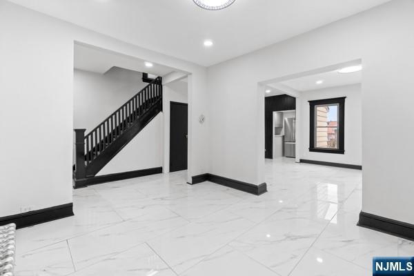 foyer featuring recessed lighting, marble finish floor, stairway, and baseboards