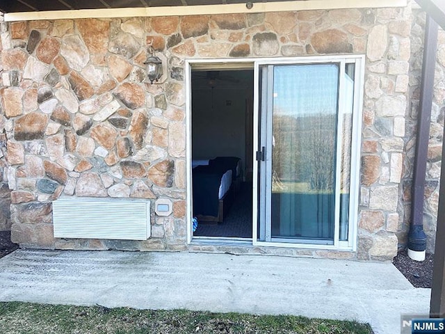 property entrance featuring stone siding and visible vents