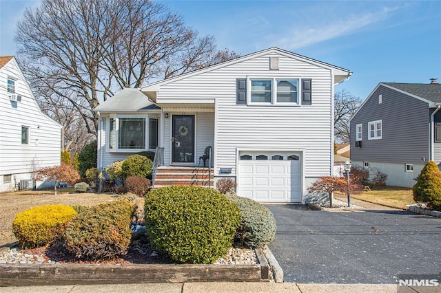 split level home with aphalt driveway and a garage