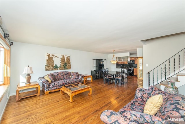 living area featuring stairway and wood finished floors