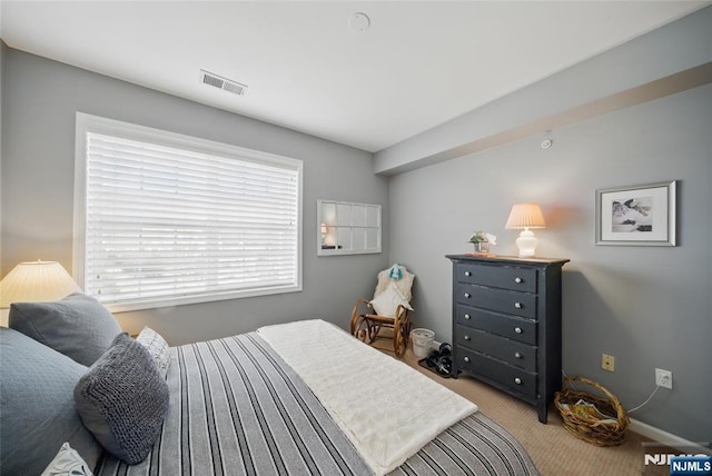 carpeted bedroom featuring visible vents