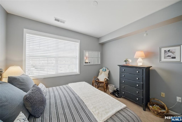 bedroom featuring light colored carpet and visible vents