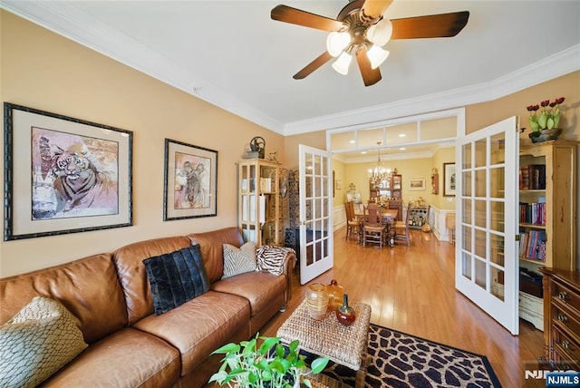 living room featuring ceiling fan with notable chandelier, french doors, wood finished floors, and crown molding