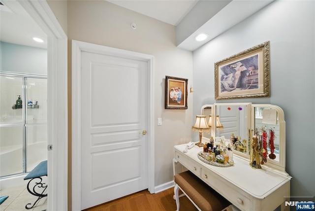 interior space with baseboards, wood finished floors, and recessed lighting