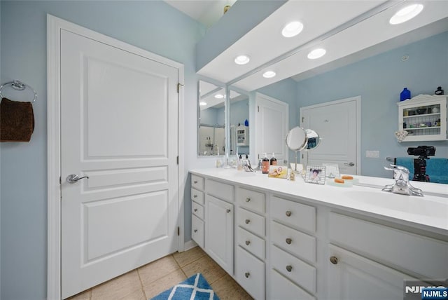 bathroom featuring recessed lighting, double vanity, a sink, and tile patterned floors