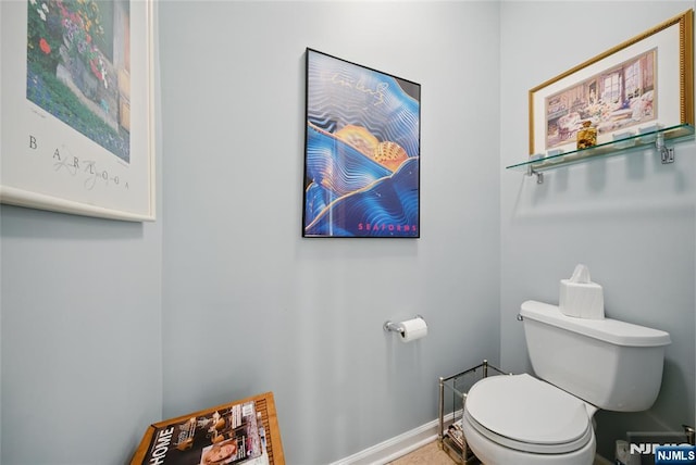 bathroom with toilet and baseboards