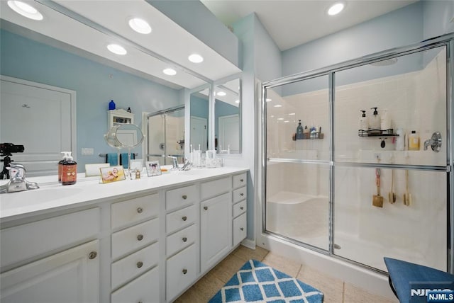 full bathroom featuring double vanity, a stall shower, tile patterned floors, a sink, and recessed lighting