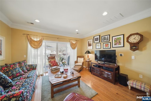 living room featuring recessed lighting, visible vents, crown molding, and light wood-style flooring