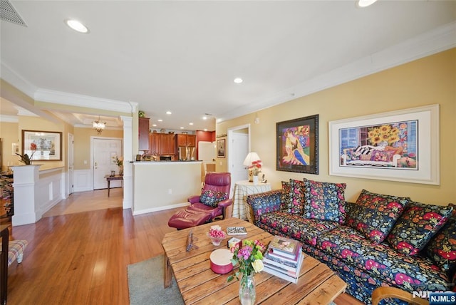 living area featuring decorative columns, visible vents, light wood-style flooring, ornamental molding, and recessed lighting