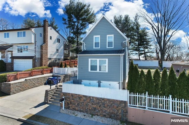 exterior space with a fenced front yard and a shingled roof