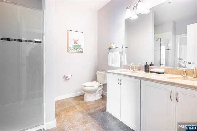 full bathroom with a sink, a shower stall, toilet, and double vanity