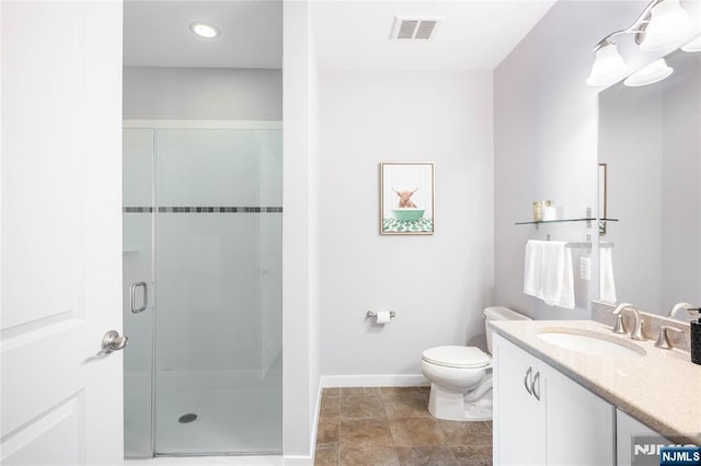 bathroom featuring toilet, vanity, visible vents, baseboards, and a stall shower