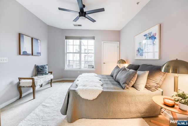 bedroom featuring light carpet, baseboards, visible vents, and a ceiling fan