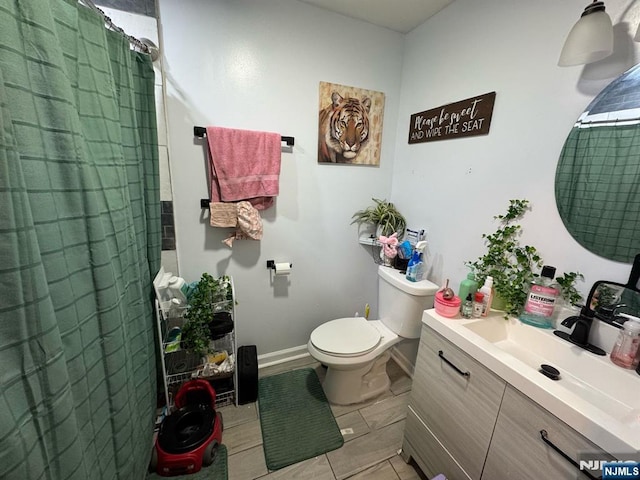 full bathroom featuring toilet, curtained shower, baseboards, and vanity