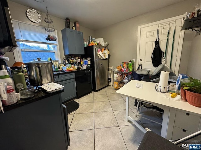 kitchen with freestanding refrigerator, light tile patterned flooring, dishwasher, and dark countertops