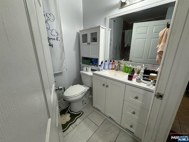 bathroom featuring toilet, tile patterned flooring, and vanity